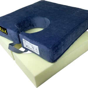 Mörkblå fyrkantig sittkudde med U-formad urtag på vit underdel. Ett handtag sitter på sidan. Märke "BAK" och etikett med detaljer på ovansidan. Utformad för komfort och tryckavlastning vid sittande.