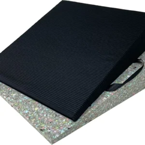 Kilformad sittdyna med svart ribbad yta placerad ovanpå en färgglad skumplastbas. Dynan har ett praktiskt handtag på sidan för enkel transport. Idealisk för att förbättra sittkomfort och ergonomi.